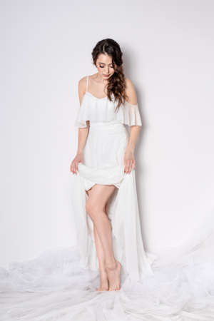 Beautiful sexy woman brunette in fashion long dress for party wedding. Bride natural model with natural makeup style for celebrity white backgroundの写真素材