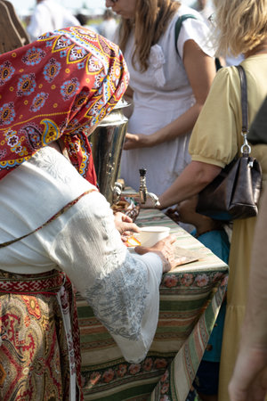 elderly woman serving tea at the fairの写真素材
