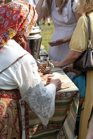 elderly woman serving tea at the fairの写真素材