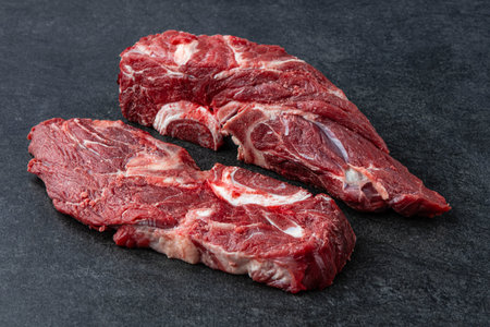 Fresh and raw fillet meat. Whole piece of beef tenderloin steaks set on black stone table background, no decorationの写真素材