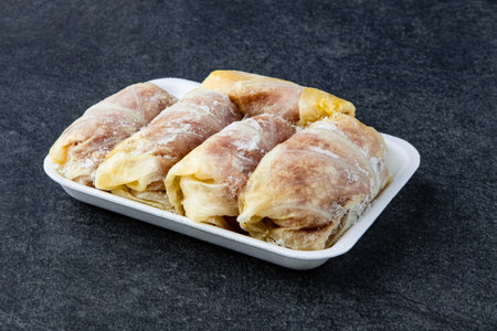 Frozen preparing tasty stuffed cabbage rolls on table in kitchenの写真素材