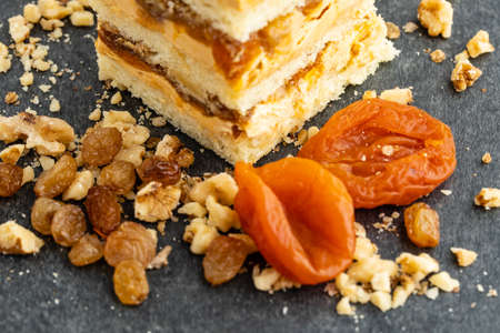 tartlet with nuts and fruits poured with caramel, the ingredients used in the tartlet are hazelnuts, peanuts, dried apricots, dried plums, dried walnutsの写真素材