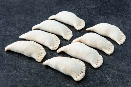 Frozen traditional russian pelmeni on gray stone table. Homemade dumplings. Semi-finished productsの写真素材