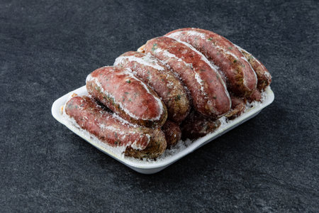 Frozen Raw sausage semi-finished products lie on a stone board. The concept of cooking from semi-finished productsの写真素材
