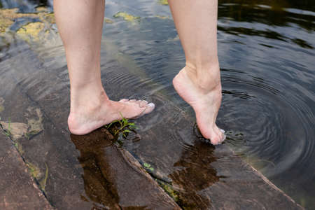 Feet immersed in the clear water, Feet in water. Selfie of legs and barefoot. vacation at summer holidayの写真素材