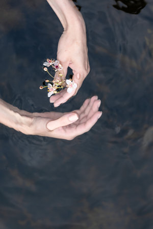 The female hand that touches the blue water. The lake is clean. With a drop of water on the water