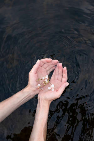 Young woman's hand touching the water in the seaの写真素材