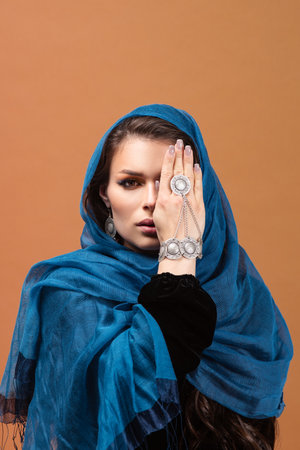 Portrait of a beautiful fashionable european woman in a blue Muslim headscarfの写真素材