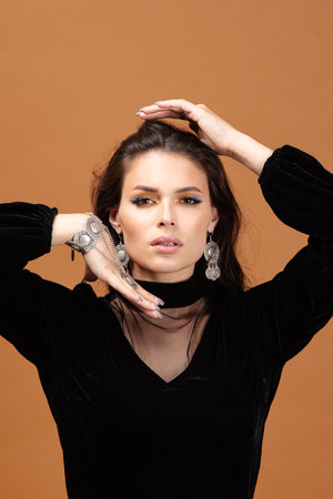 Beautiful woman face with healthy skin and hair on brown backgroundの写真素材