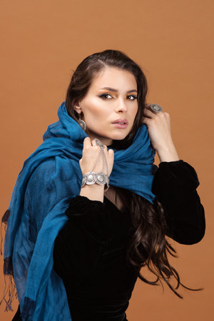 Smiling, dreamful young woman's portrait on amber studio background. Beautiful female model in casual style.の写真素材