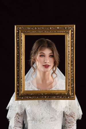 Bride in white deress taking a frame in front of their facesの写真素材
