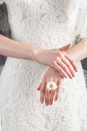 Portrait of a young woman in a wedding image. Wedding hairstyle and bright makeup. A elegant white flower in her handsの写真素材