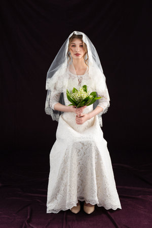 Portrait of a young woman in a wedding image. Wedding hairstyle and bright makeup. A elegant white flower in her handsの写真素材
