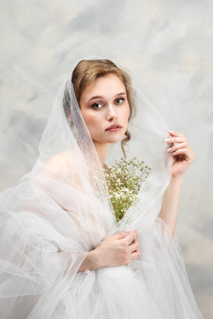 Beautiful pregnant woman with flowers on belly. Young woman in maternity waiting for baby birth. Pregnancy, Motherhood, Mother's Day Holiday concept.の写真素材