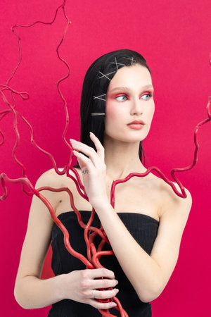 tenderness. Portrait of young beautiful girl with long curly hair looking at camera isolated on red background. female student. Concept of youth, beauty, life. Copy space for adの写真素材
