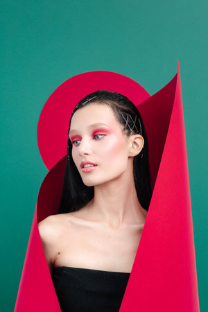 Photo of adorable charming young woman with photo frame with geometry figures, copy spaceの写真素材