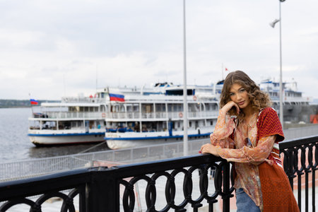 Portrait of a beautiful girl on the background of the embankment of a large riverの写真素材