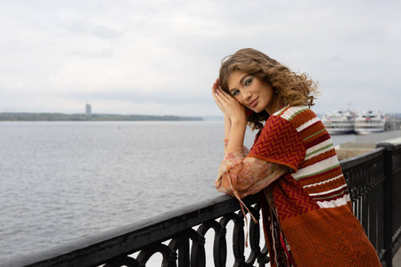 lifestyle elegant young woman on the embankment of a large river looks at the riverの写真素材