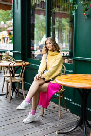 young woman sitting at a caffee in amusement parkの写真素材