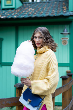 A young girl eating cotton candy. Rest in the amusement parkの写真素材
