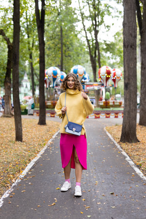 Woman in an amusement park look on a carousel and smiles with happiness, the concept of weekendsの写真素材