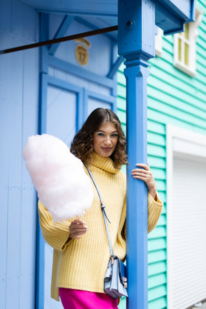 A young girl eating cotton candy. Rest in the amusement parkの写真素材