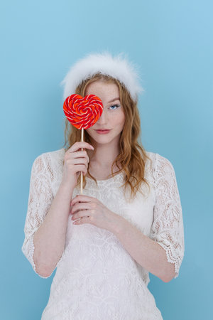 Closeup of woman's holding a heart lolipop in front of herの写真素材