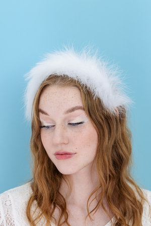 beautiful blond woman wearing white feather hair flower curly hairの写真素材