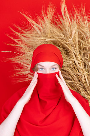 Young asian muslim woman with beautiful eyes covering her face with scarf isolated on white backgroundの写真素材