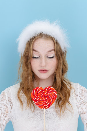 Portrait of romantic classy trend girl dream perfect 14-february dating hold heart shape lolipop over bright blue color backgroundの写真素材