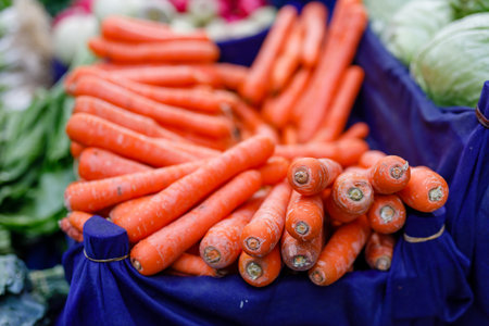 Organic vegetables on counter, fresh local produce homegrown raw veggies at marketplace stall. Agricultural farm selling harvest.の写真素材