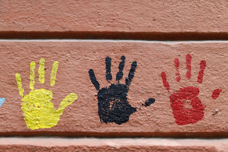 Colored kid hands painted on wall, friends conceptの写真素材