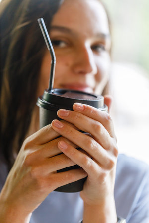 Paper cup with coffee in female hands. close-up viewの写真素材