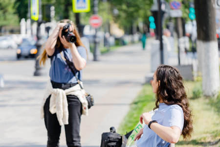 Interested female photographer working on the street. Outdoor photo of woman photographer with cameraの写真素材