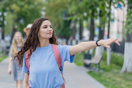 young girl shows the direction to the right with her handの写真素材