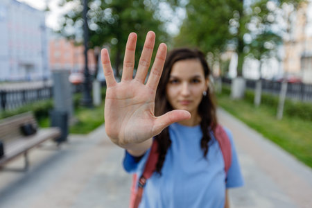 Woman gesturing stop with hand outstretched forward. street female portrait.の写真素材