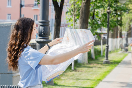 girl holding map, tourist searching way, travelling, standing over white backgroundの写真素材