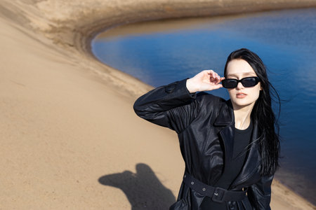 Person in warm coat outdoor posing and looking at sunrise. Cold fall morning by the lake.の写真素材