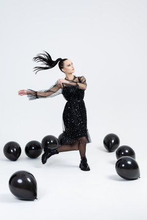 Beautiful young girl with stilish black balloons, Joyful model. Fashion beauty SPA conceptの写真素材