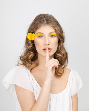 Happy smiling young woman holding yellow dandelion flowerの写真素材