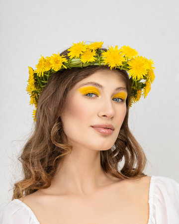 Young woman in national clothes wearing yellow dandelion wreathの写真素材