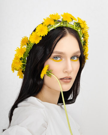 Young woman in national clothes wearing yellow dandelion wreathの写真素材