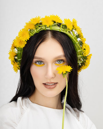 Closeup portrait Young woman in wreath from yellow dandelions.の写真素材