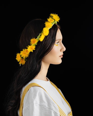 Young woman in national clothes wearing yellow dandelion wreathの写真素材