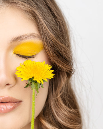 Closeup portrait Young woman in wreath from yellow dandelions.の写真素材