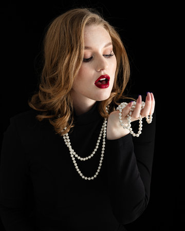 portrait of a beautiful young girl with freckles on her face and wearing a black dressの写真素材