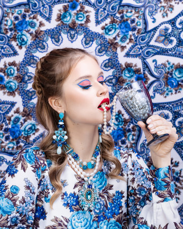 Fashion photo of a beautiful elegant young woman in a cute suit with flowersの写真素材