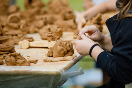 Children's lesson for modeling from Natural terracotta clay piece held in hands. Wet clay material for sculpture or modelingの写真素材