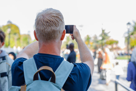 A traveler takes photographs of a mosque on the other side of the Golden Horn in Istanbul
