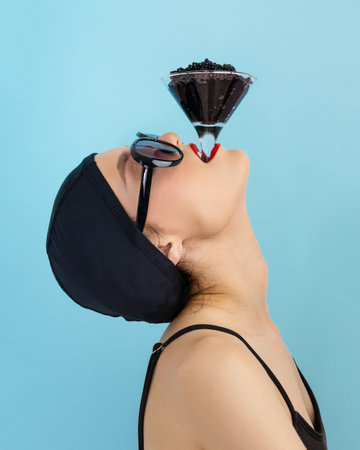 Beautiful Fashion Model woman eating black caviar. Fashion female with spoon of black Caviarの写真素材